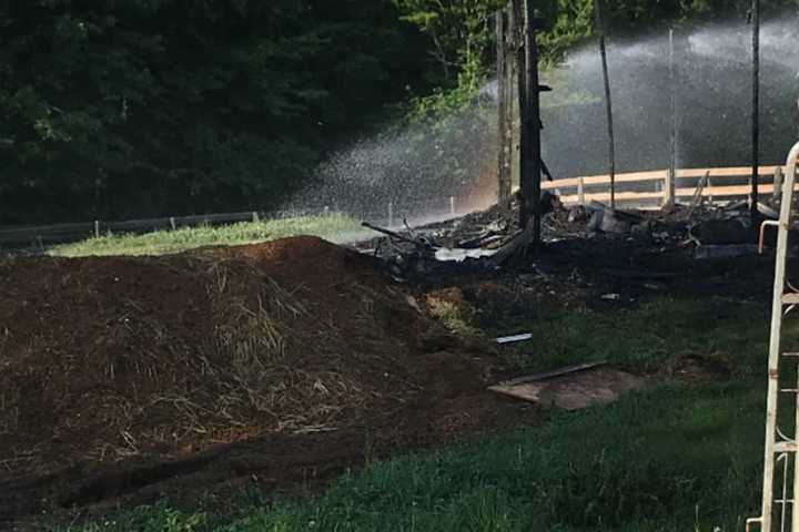 The smoldering remains of a barn fire that killed 24 horses.