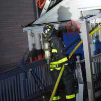 <p>A firefighter holding a hose at the scene of the fire.</p>