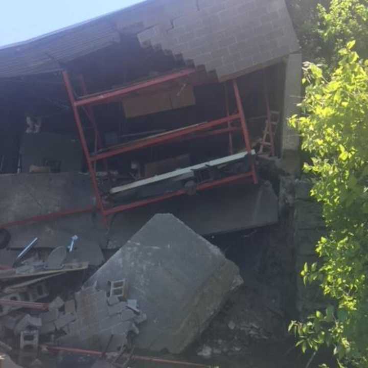 A building partially collapsed in Shelton on Tuesday afternoon, sending debris careening into the Housatonic River below.