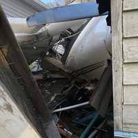 <p>The plane wedged between the shed and the house.</p>