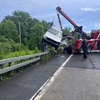 <p>The SUV is being lifted out of the creek by a tow truck.</p>