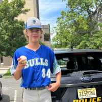 <p>Sol Elmer poses with police after his home run ball damaged a police car.</p>