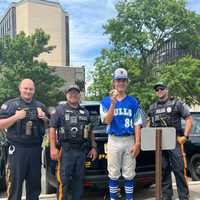 <p>Sol Elmer poses with police after his home run ball damaged a police car.</p>