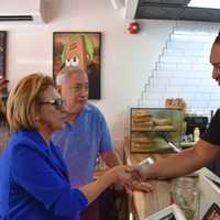 <p>North Bergen Mayor Nicholas Sacco and Township Administrator Janet Castro watch as Commissioner Claudia Rodriguez shakes hands with Markin Delacruz as he opens Sandwichitos.</p>