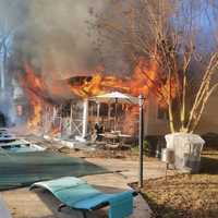 <p>A plastic container used to store used ash from a wood stove was ignited by hot embers which then spread to a wooden fence.</p>