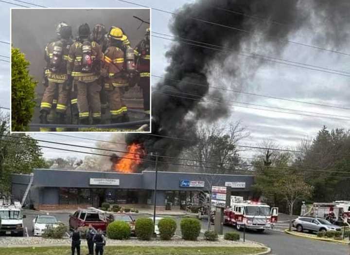 Photos show flames shooting from the roof of Jays Food Mart and Cuzzin's Pizzeria in the strip mall on Herbertsville Road.