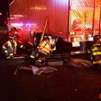 <p>Westport firefighters work to free a van that was under a tractor-trailer.</p>