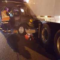 <p>Firefighters work to help the driver of the van who slammed into a tractor-trailer.</p>