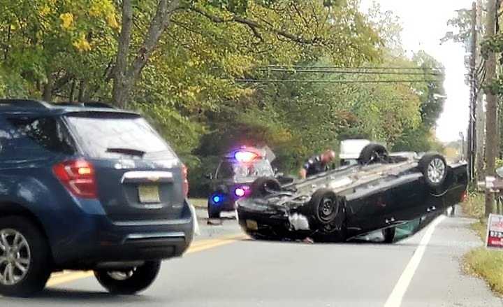 The vehicle hit a sign on the other side of the road and overturned, a witness said.