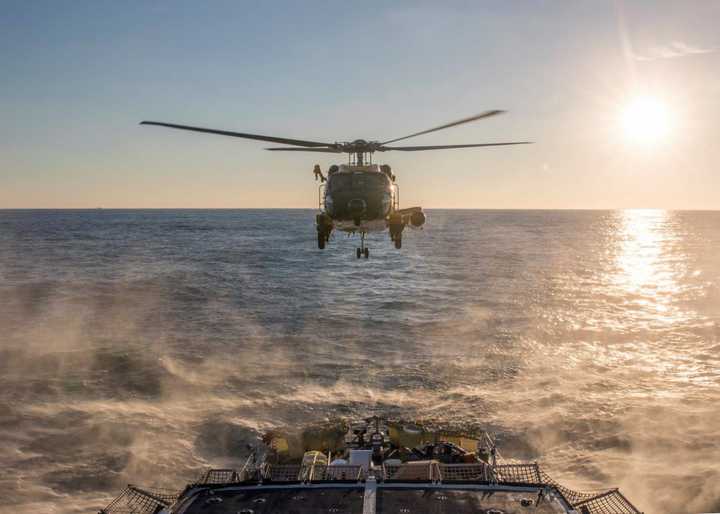 Coast Guard officials rescued three fishermen from a commercial boat that was taking on water and sinking.