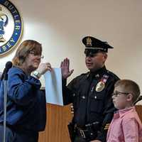 <p>Sgt. Reyes being sworn in with his son, 7.</p>