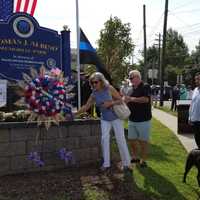 <p>Members of Officer Albino&#x27;s family place a rose.</p>