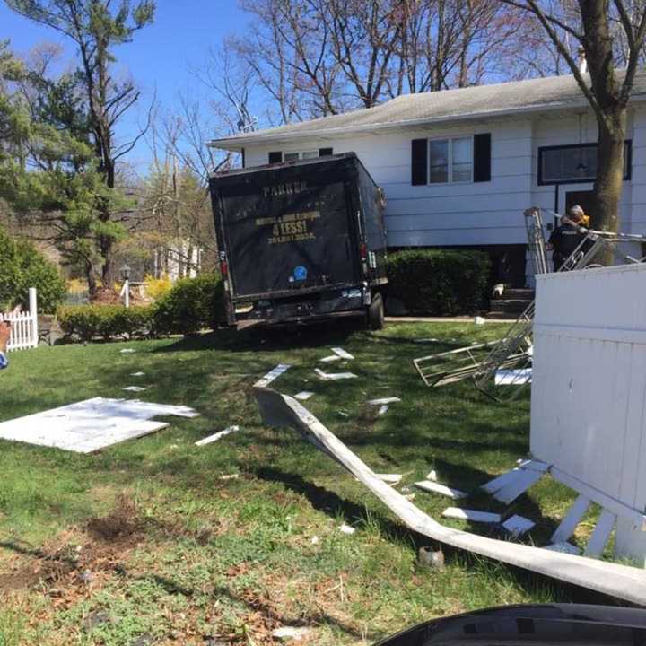 A large moving truck plowed into the front of a home.