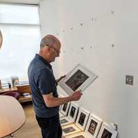 <p>Phil Cantor hangs his photos in the gallery.</p>