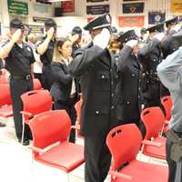 <p>New graduates salute as they are sworn in.</p>