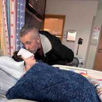 <p>Coley Cand receiving a forehead kiss while recovering from the first surgery of the experimental procedure.</p>