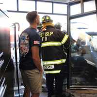 <p>Firefighters remove the building&#x27;s storefront.</p>