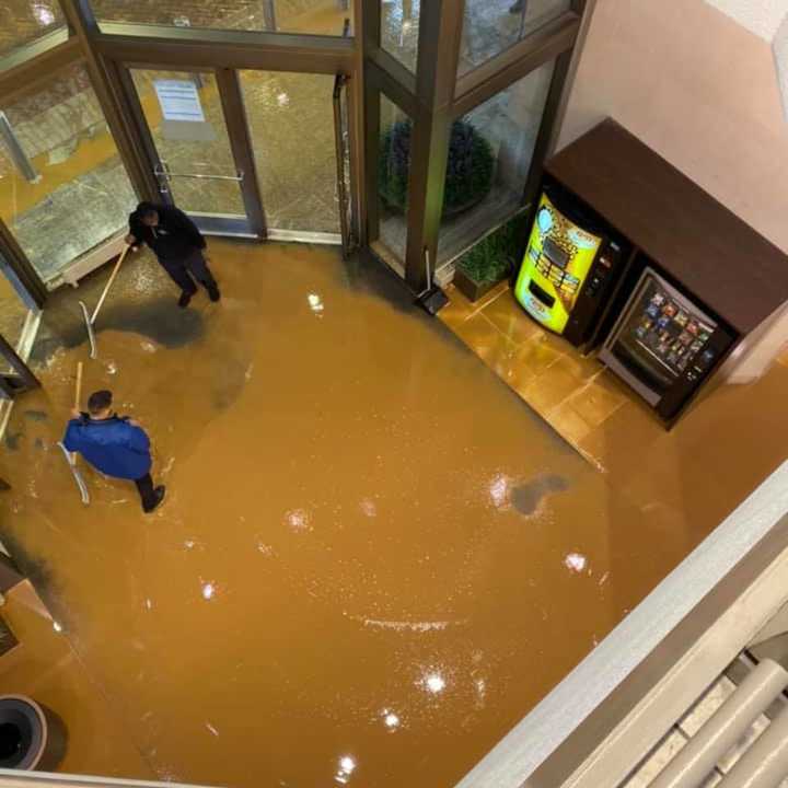 Workers clean up after a main burst beneath the Mall at Short Hills Monday