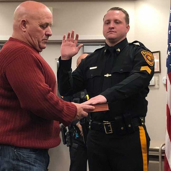 Retired Englewood Police Sgt. James Morgan holds the Bible as his son, James, is sworn in during Haworth&#x27;s Mayor and Council meeting.