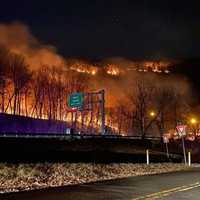 <p>The Mount Tammany wildfire burns Sunday night over Route 80.</p>