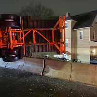 <p>A tractor-trailer rollover crash threatened a neighborhood below.</p>