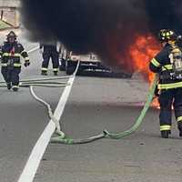 <p>Washington Township firefighters douse the car fire on the Garden State Parkway.</p>