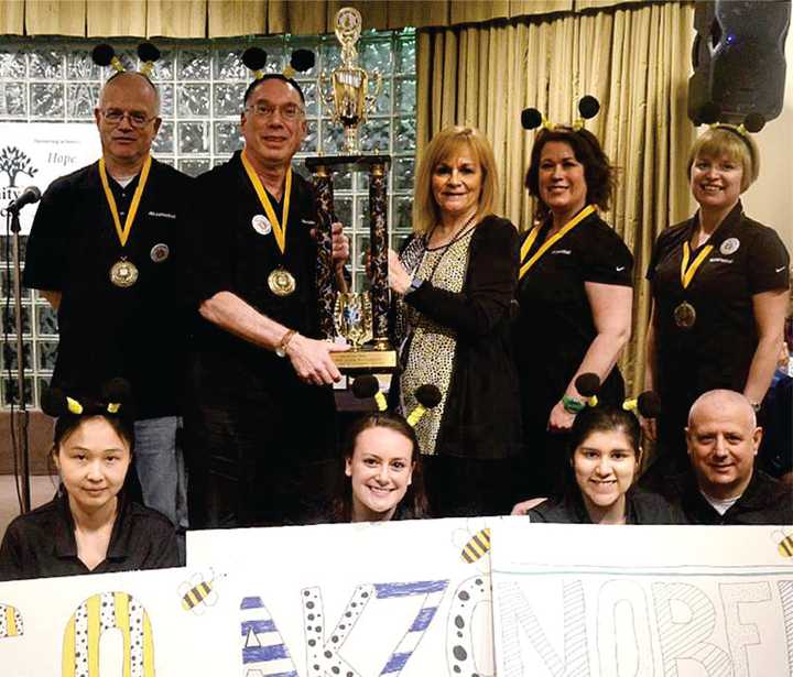 Members of the Akzo Nobel Bees pose for a photo after making a repeat win at the 7th-annual Putnam Family &amp; Community Services Adult Spelling Bee.