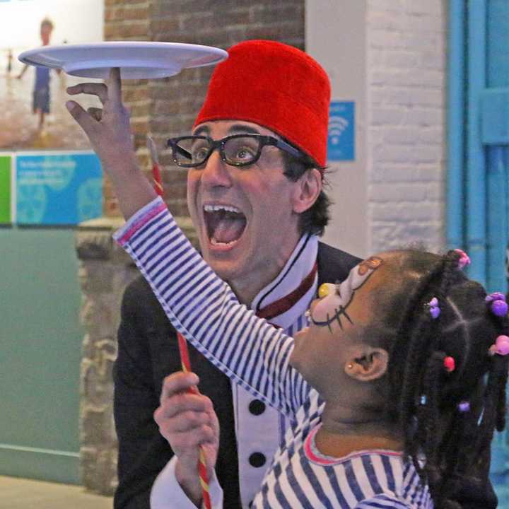 Comedian/juggler Peter Straus clowns with a young guest and a spinning plate during last year’s New Year’s Eve celebration at The Maritime Aquarium at Norwalk.