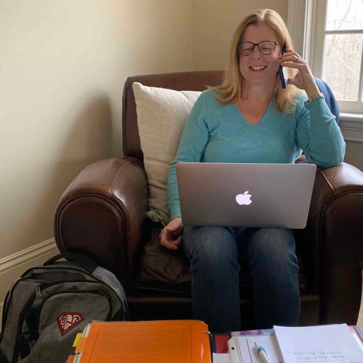 New Canaan High School Nurse Betsy Imbrogno talks on the phone to a New Canaan resident.