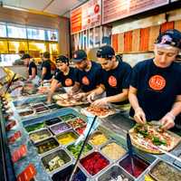 <p>Customers can experience an interactive open-kitchen format that allows guests to customize one of the menu’s signature pizzas or create their own.</p>