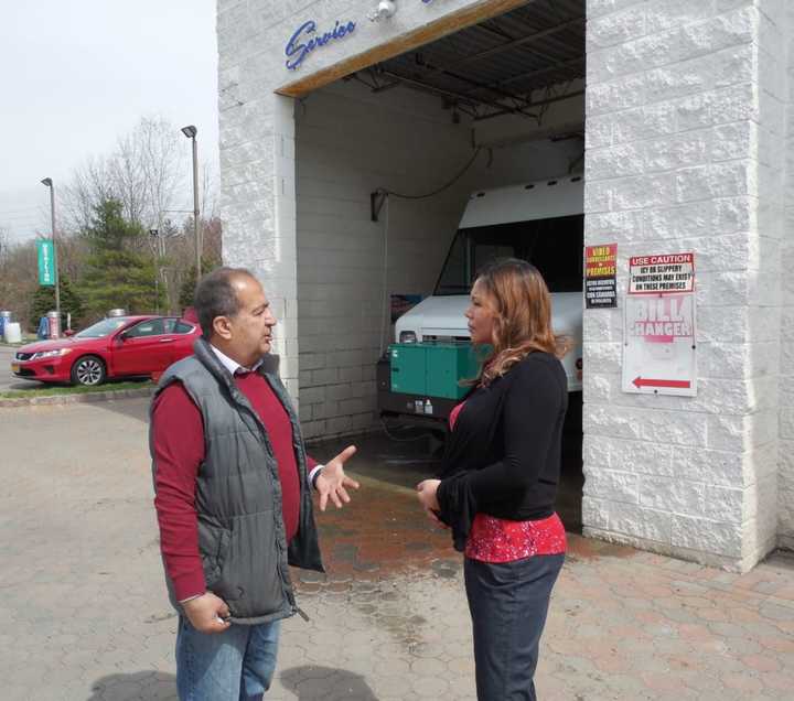 Raymond Ahmadi, left, at his carwash in Pearl River, discusses his brush with a crook on the telephone with O&amp;R’s Shoko Saito, right, who broke up the robbery attempt.