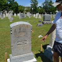 <p>Robert Neal Carpenter points to a headstone he fixed at the Wyckoff Reformed Church Cemetery.</p>