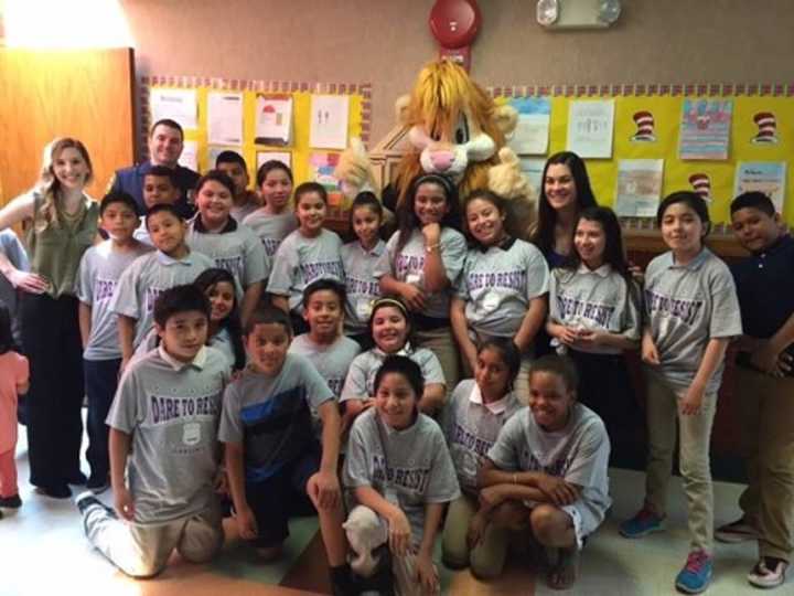 Students from Elmwood Elementary School in Monsey celebrate graduating from the Ramapo Police Department&#x27;s D.A.R.E. program with Ramapo Police Officer Danny Lynch, rear left, and mascot, Daren the D.A.R.E. Lion.