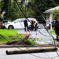 <p>EMS workers and police tend to the driver whose SUV hit a utility pole and landed on its side in the driveway of a Glen Rock home.</p>