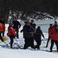 <p>Responders ashore pull in the canoe.</p>