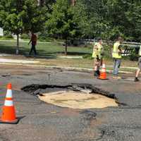 <p>The road buckled under the water pressure, leaving a gaping hole.</p>