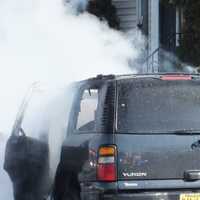 <p>Firefighters tend to the SUV and the house after the crash in Hawthorne.</p>