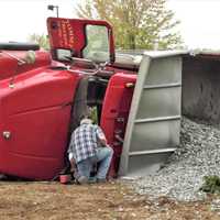 <p>The driver inspects the inside of his cab after the rig tumbled on northbound Route 17 in Mahwah.</p>