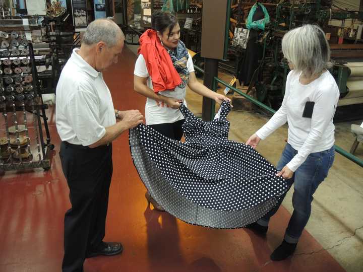 Profession William Filerino, Palenia Pichardo and Cristina Deutsch show off a dress at the Paterson Museum.