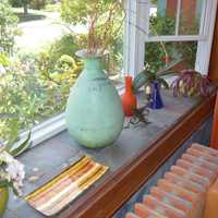 <p>The windowsill features unqiue vases.</p>