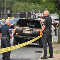 <p>Uniformed Paterson police officers and investigators work the scene following the shooting on West Broadway near Oxford Street around 6 p.m. Monday, May 22.</p>