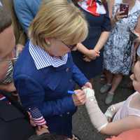 <p>Hillary Clinton autographs a girl&#x27;s cast prior to the start of New Castle&#x27;s 2016 Memorial Day parade.</p>