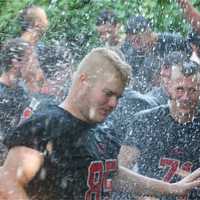 <p>Rye players celebrate their historic win by jumping in the creek, after beating Harrison.</p>