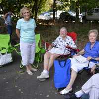 <p>A group of ladies enjoy the sunny day under the shade during the car show.</p>