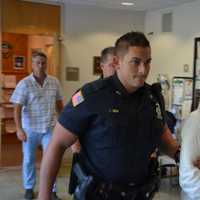 <p>Hengjun Chao, the suspect in Monday&#x27;s shooting at Lange&#x27;s deli in Chappaqua, is escorted by New Castle Police to his arraignment.</p>