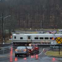 <p>A Metro-North train speeds through the Roaring Brook Road grade crossing in Chappaqua.</p>