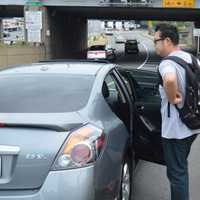 <p>Nick Bai gets into a car for a ride across the bridge.</p>