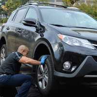 <p>Roberto Gonzalez of Nomad Oil rotating tires on a service road behind the Meadows Office Complex in Rutherford.</p>