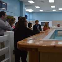 <p>Owner Angela Pantalone, center, shows visitors the pooch pool at Wag Central in Stratford.</p>