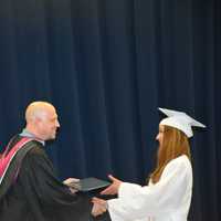<p>A newly minted Carmel High School graduate receives her diploma at the 2016 commencement.</p>